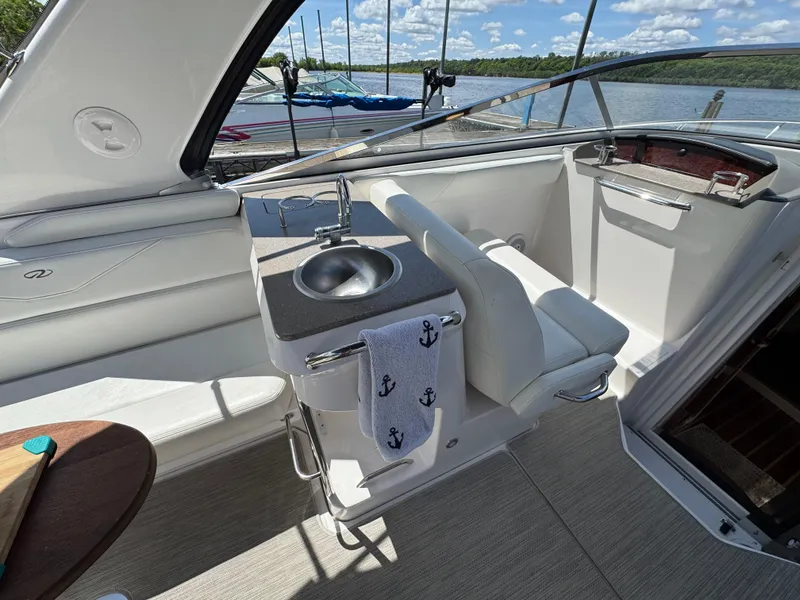 Slide: The Image of 2011 Regal 3350 Cuddy boat interior with sink, seating, and nautical decor. - 30