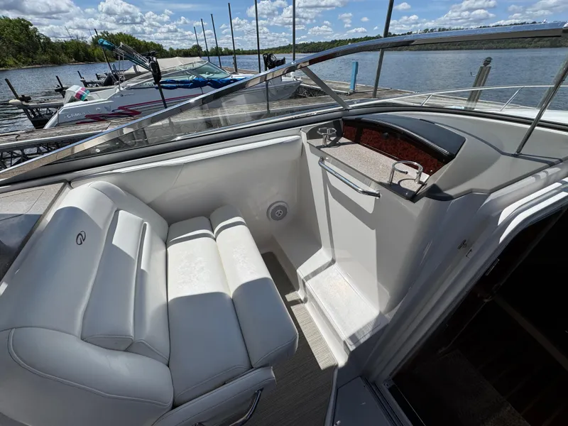 Slide: The Image of 2011 Regal 3350 Cuddy boat interior with white seating, docked by a scenic lake. - 31