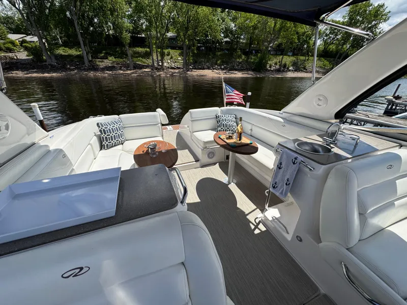 Slide: The Image of Luxurious 2011 Regal 3350 Cuddy boat interior with seating, tables, and American flag. - 33