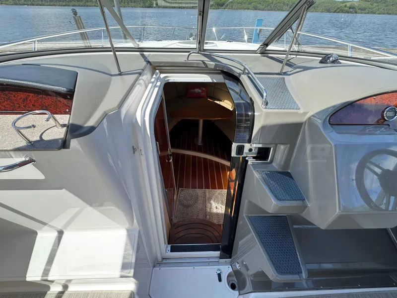 Slide: The Image of 2011 Regal 3350 Cuddy boat interior with open cabin door, showing wooden flooring. - 34