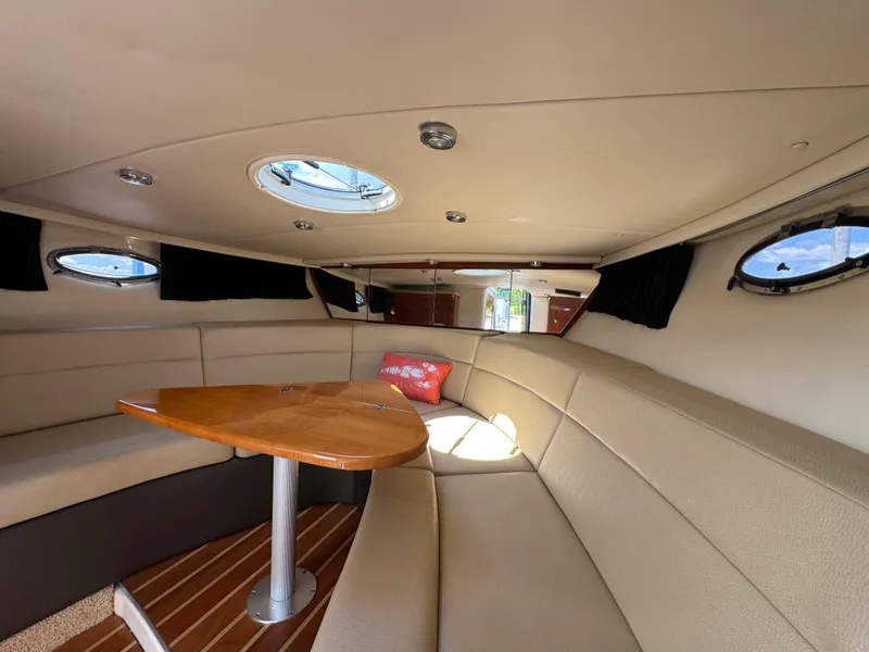 Slide: The Image of Interior of 2011 Regal 3350 Cuddy boat with beige seating and wooden table. - 36