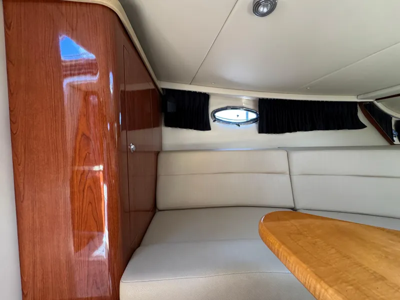 Slide: The Image of Interior of 2011 Regal 3350 Cuddy with wood paneling and cushioned seating. - 37