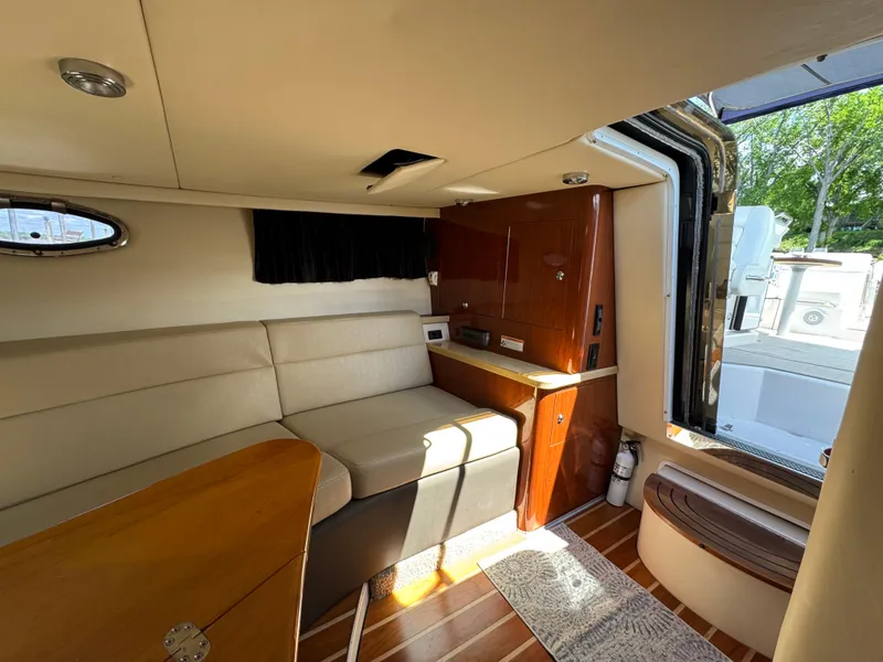 Slide: The Image of 2011 Regal 3350 Cuddy interior with seating, wood accents, and open hatch. - 39