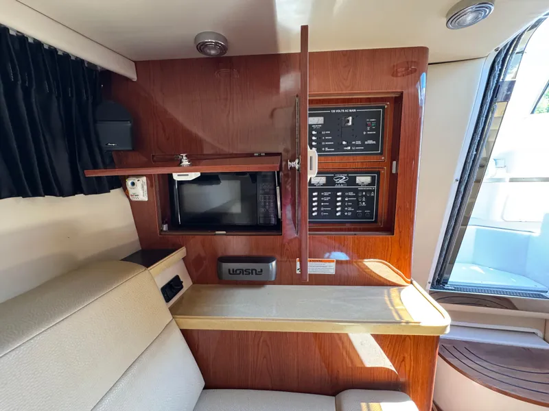 Slide: The Image of 2011 Regal 3350 Cuddy interior with control panel, seating, and wooden cabinetry. - 40