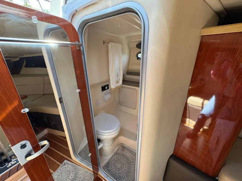 Slide: The Image of 2011 Regal 3350 Cuddy boat interior with compact bathroom and wooden accents. - 43
