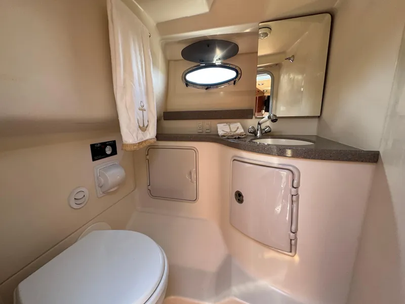 Slide: The Image of 2011 Regal 3350 Cuddy bathroom with sink, toilet, and storage cabinets. - 44
