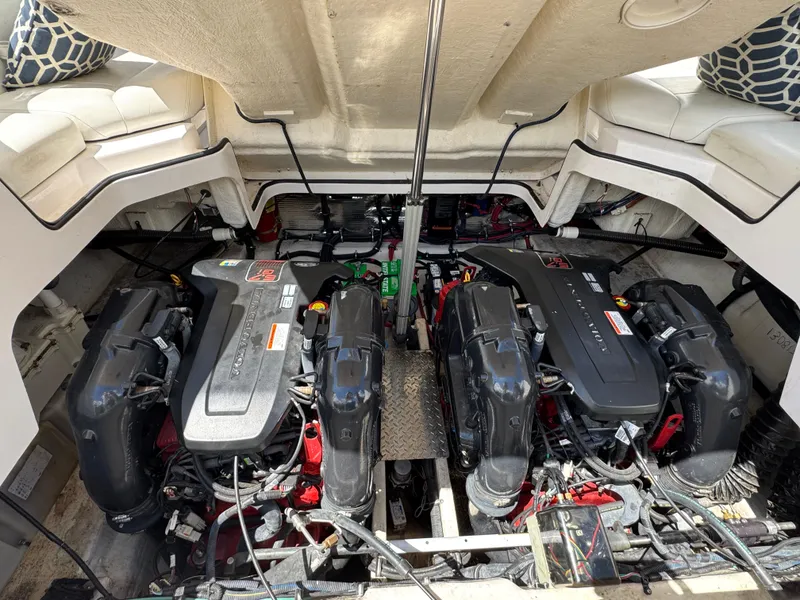 Slide: The Image of Engine compartment of a 2011 Regal 3350 Cuddy boat, showcasing dual engines and seating area. - 46