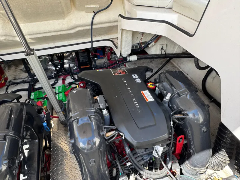 Slide: The Image of Engine compartment of a 2011 Regal 3350 Cuddy boat, showcasing dual engines and components. - 49