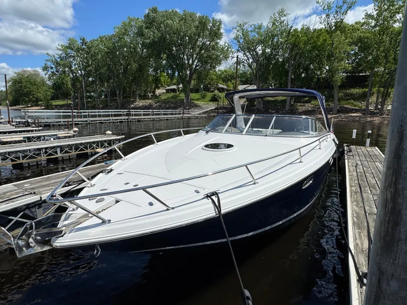 Slide: The Image of 2011 Regal 3350 Cuddy boat docked at a marina, surrounded by trees and clear skies. - 6