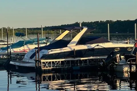 Slide: The Image of 2011 Regal 3350 Cuddy boat docked on a serene lake at sunset. - 9