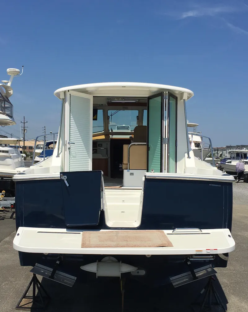 Slide: The Image of 2026 Back Cove 372 yacht, rear view, docked under clear blue sky. - 3