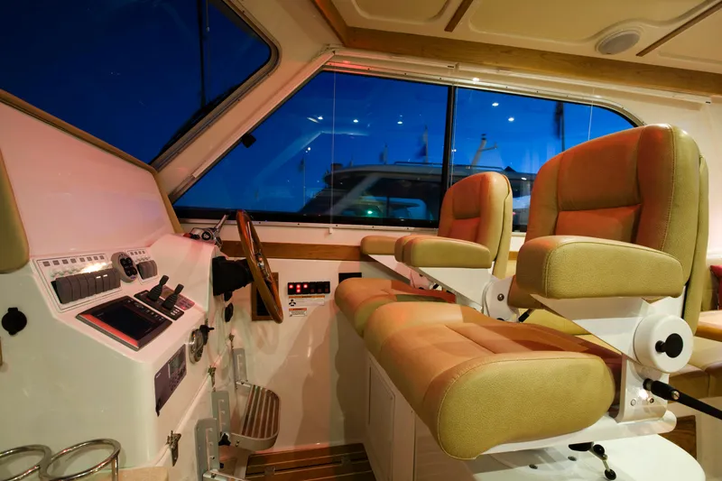 Slide: The Image of 2026 Back Cove 372 boat interior with helm station and two cushioned seats. - 4
