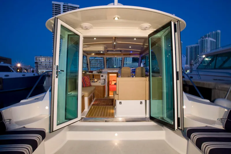 Slide: The Image of 2026 Back Cove 372 yacht interior with open glass doors, docked at marina. - 5