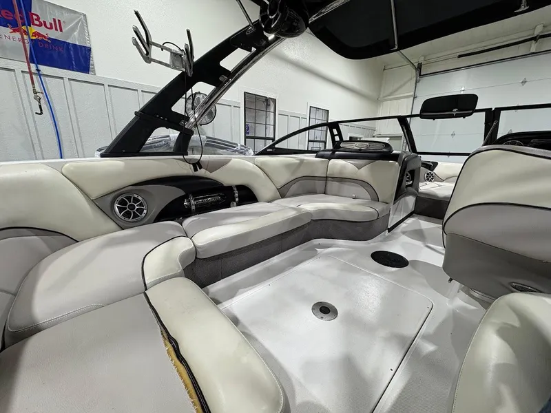 Slide: The Image of 2011 Malibu Wakesetter 21 VLX interior with white and gray seating in a garage. - 11