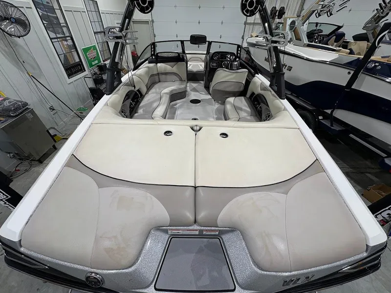 Slide: The Image of 2011 Malibu Wakesetter 21 VLX boat interior with beige and gray seating in a garage. - 15