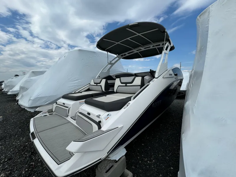 Slide: The Image of 2021 Yamaha Boats 275SE with canopy, docked outdoors under cloudy sky. - 6