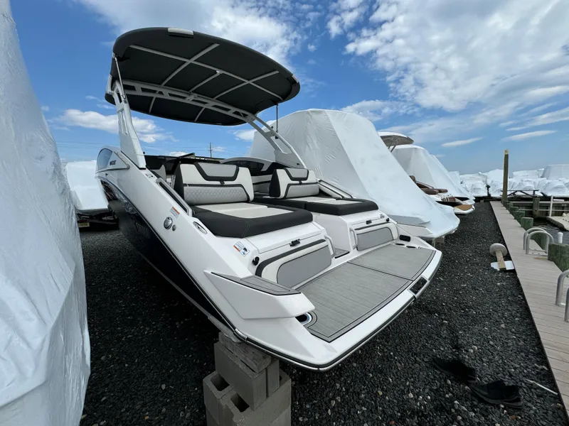 Slide: The Image of 2021 Yamaha Boats 275SE on display, featuring sleek design and spacious seating under a cloudy sky. - 7