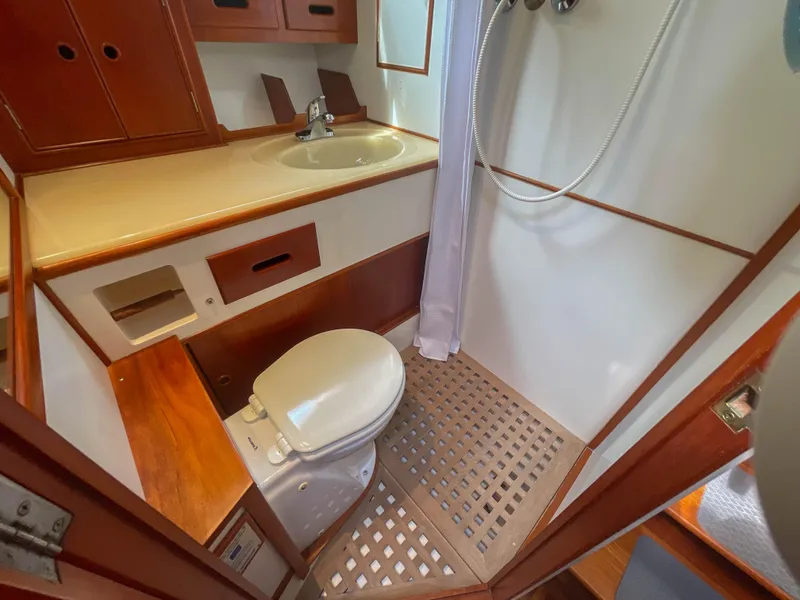 Slide: The Image of 1989 Grand Banks 42 Classic yacht bathroom with wooden cabinetry and shower area. - 18