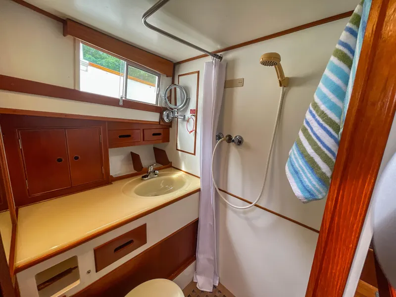 Slide: The Image of 1989 Grand Banks 42 Classic yacht bathroom with shower, sink, and striped towel. - 19