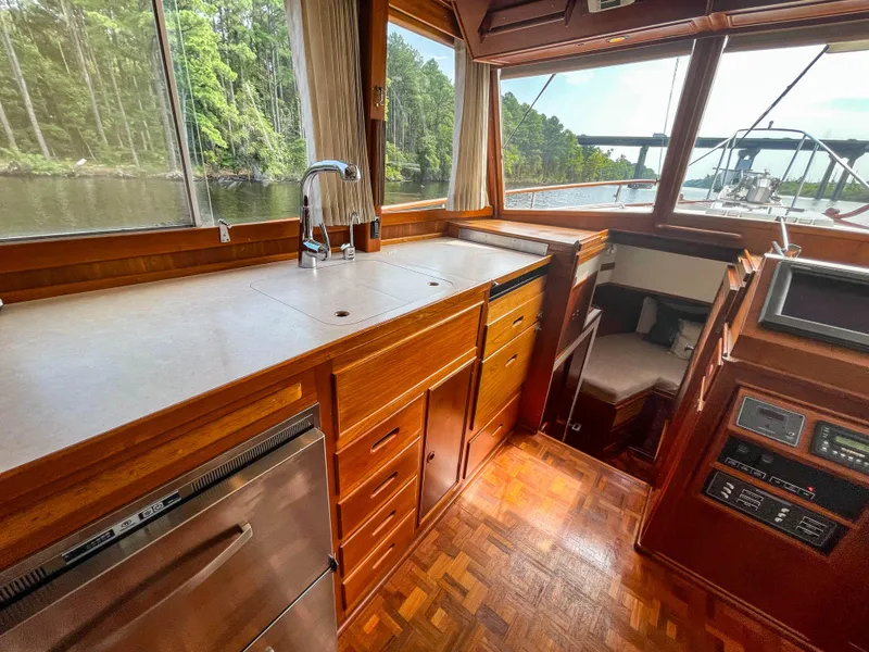 Slide: The Image of 1989 Grand Banks 42 Classic yacht interior with wood cabinetry and scenic waterway view. - 21