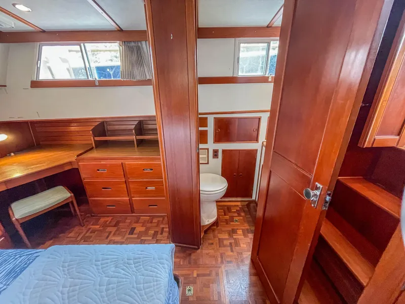 Slide: The Image of 1989 Grand Banks 42 Classic cabin interior with wood finish, desk, and bathroom. - 39