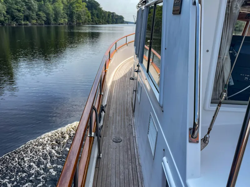 Slide: The Image of Side view of 1989 Grand Banks 42 Classic yacht cruising on a calm river. - 46