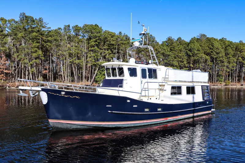 Slide: The Image of Cherubini Independence 2000 yacht cruising on a serene lake with forest backdrop. - 2