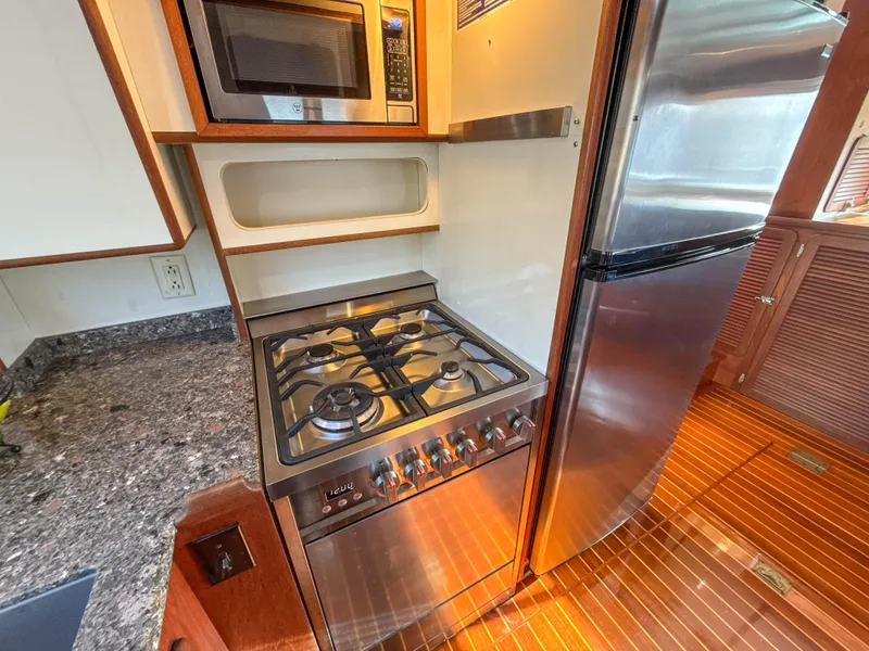 Slide: The Image of Compact kitchen in a 2000 Cherubini Independence yacht with stove, microwave, and fridge. - 26