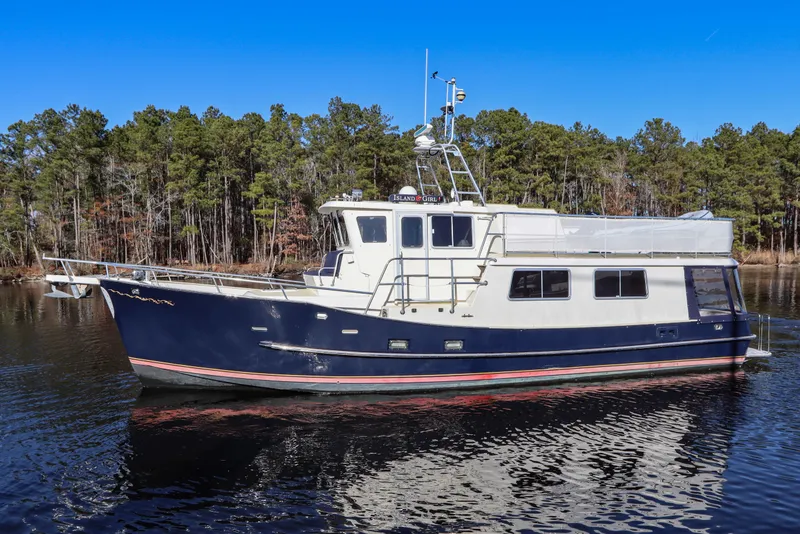 Slide: The Image of Cherubini Independence 2000 yacht on calm water with forest background. - 3