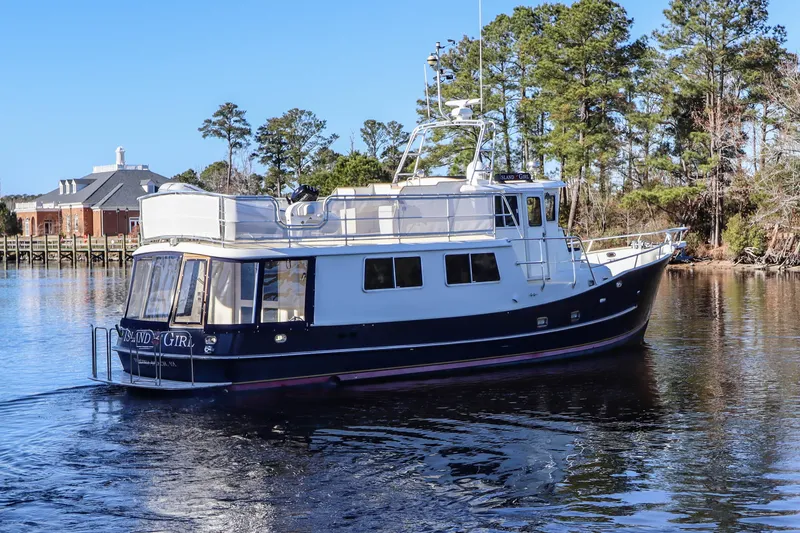 Slide: The Image of Cherubini Independence 2000 yacht on calm water, surrounded by trees and buildings. - 7