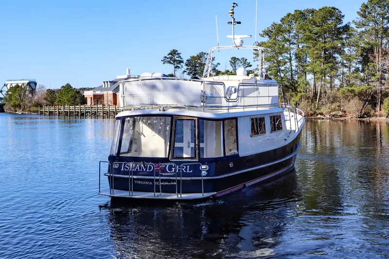 Slide: The Image of Cherubini Independence 2000 yacht "Island Girl" on a serene lake with trees in the background. - 8