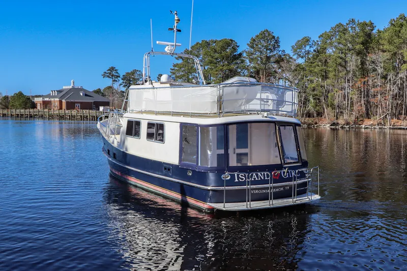 Slide: The Image of Cherubini Independence 2000 yacht on a serene lake with trees and blue sky. - 9