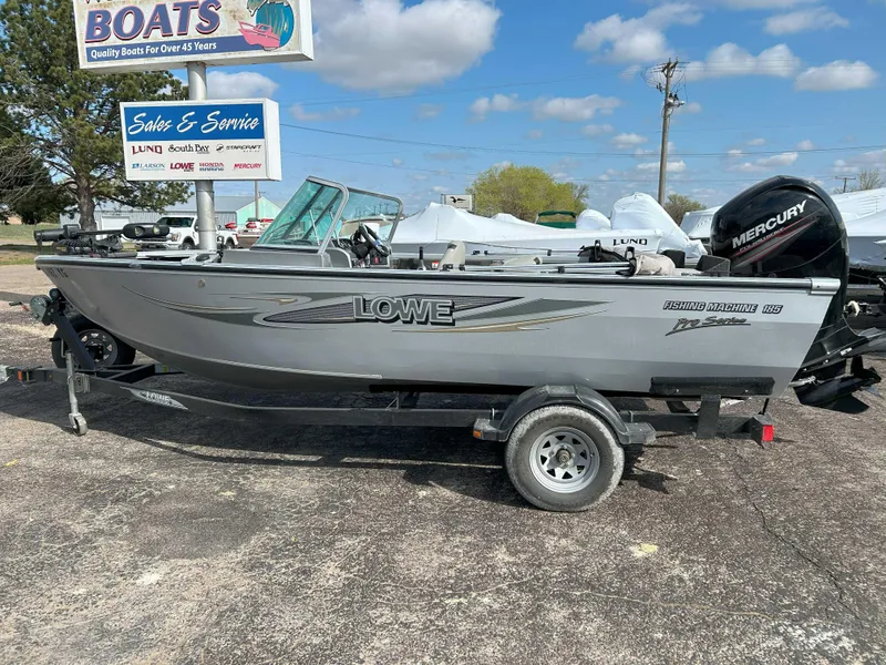 Slide: The Image of 2013 Lowe 185 Pro Series boat on trailer, parked outdoors under a blue sky. - 3