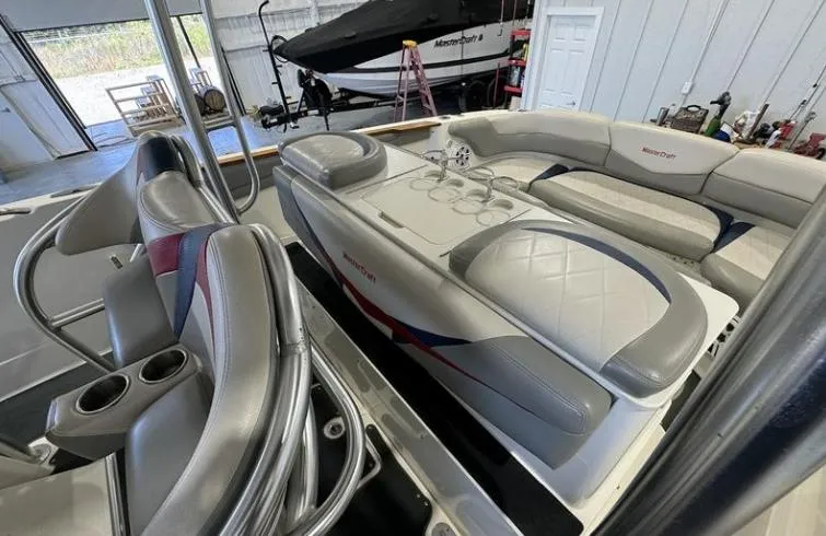 Slide: The Image of 2009 MasterCraft CSX 265 SS boat interior with gray seating and cup holders in a garage. - 10