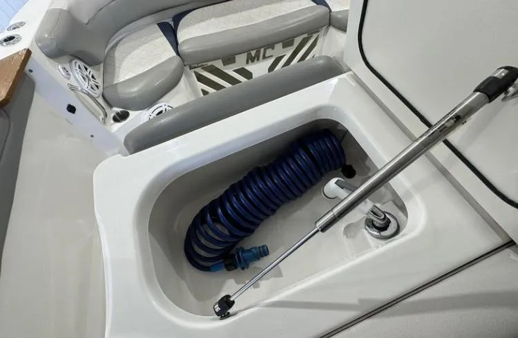 Slide: The Image of 2009 MasterCraft CSX 265 SS boat storage compartment with coiled hose and seating area. - 20