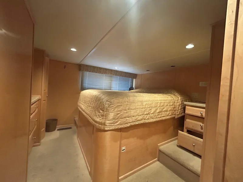 Slide: The Image of Cozy bedroom interior in 2006 American Waterways Sweet Escape houseboat, featuring elevated bed and wooden cabinetry. - 10