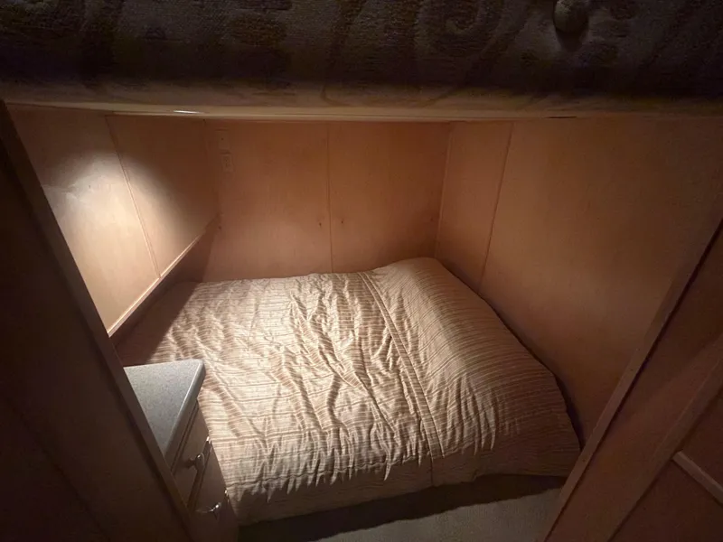 Slide: The Image of Cozy cabin bed in 2006 American Waterways Sweet Escape boat, featuring wooden walls and soft lighting. - 13