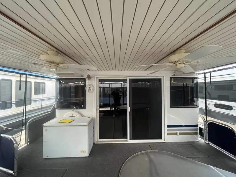 Slide: The Image of Houseboat interior with ceiling fans, sliding glass doors, and a small sink area. American Waterways, 2006 model. - 4