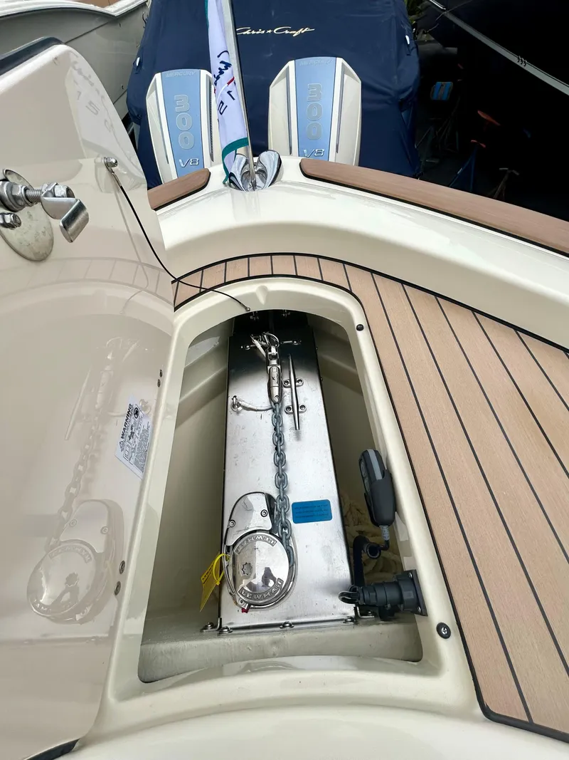 Slide: The Image of 2025 Chris-Craft 31 Catalina boat anchor compartment with teak decking and dual outboard motors. - 8