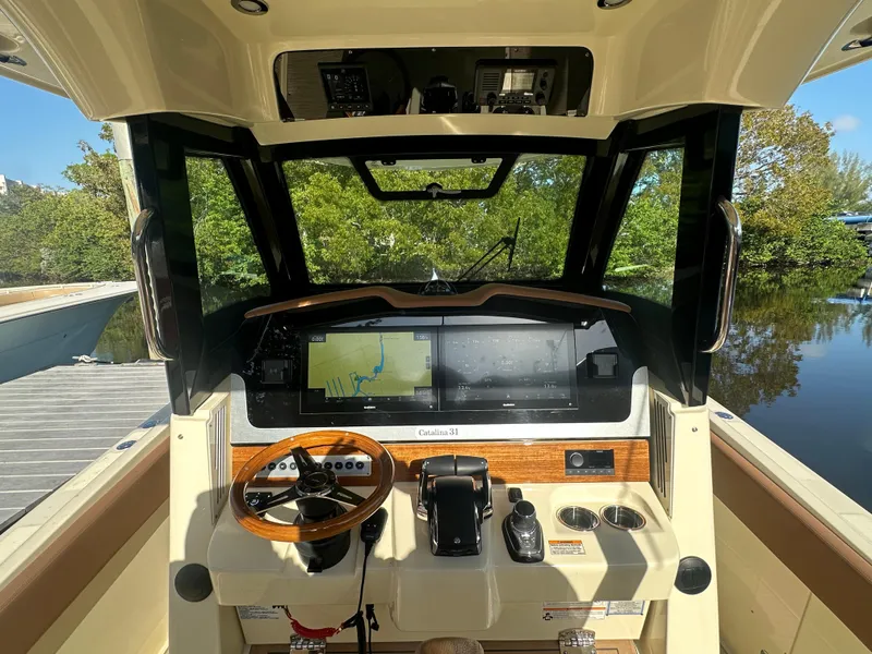 Slide: The Image of 2025 Chris-Craft Catalina boat dashboard with modern navigation system and wooden steering wheel. - 1