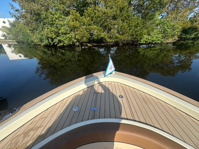 Slide: The Image of 2025 Chris-Craft Catalina boat on calm water, surrounded by lush greenery. - 4