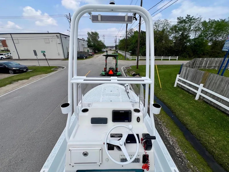 Slide: The Image of 2017 Shallow Sport 24 Sport boat on trailer, street view, clear sky, white fence. - 11