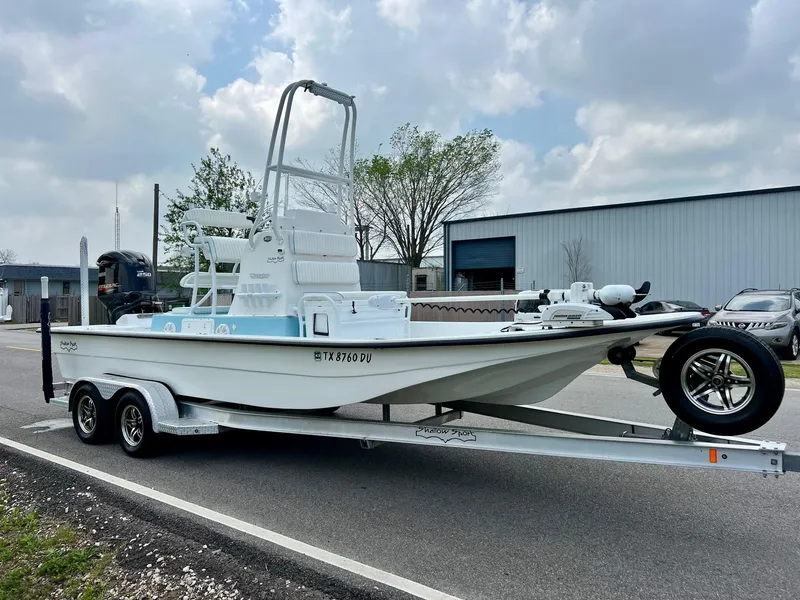 Slide: The Image of 2017 Shallow Sport 24 Sport boat on trailer, parked outdoors under cloudy sky. - 5