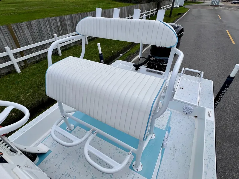 Slide: The Image of 2017 Shallow Sport 24 Sport boat with white cushioned seating and blue accents. - 9