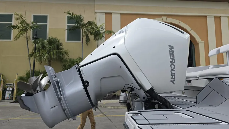 Slide: The Image of 2020 Aviara AV32 OB with Mercury outboard engine, parked near a building with palm trees. - 14