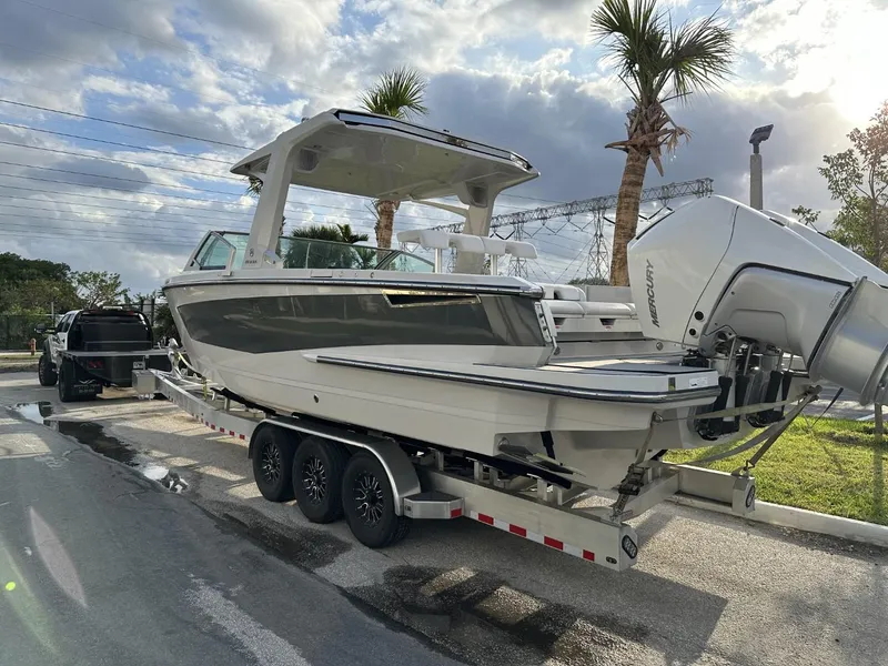 Slide: The Image of 2020 Aviara AV32 OB boat on trailer, parked near palm trees under cloudy sky. - 18