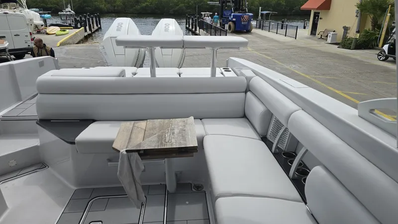 Slide: The Image of 2020 Aviara AV32 OB boat with spacious seating and wooden table, docked at marina. - 2