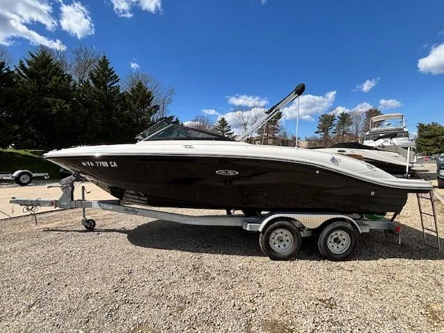 Slide: The Image of 2018 Sea Ray SPX 210 boat on trailer, parked outdoors under a clear blue sky. - 1