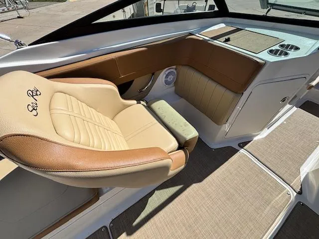 Slide: The Image of 2018 Sea Ray SPX 210 boat interior with tan leather seating and modern dashboard. - 10