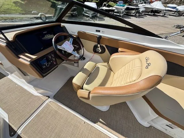 Slide: The Image of 2018 Sea Ray SPX 210 boat interior with tan leather seating and modern dashboard. - 11